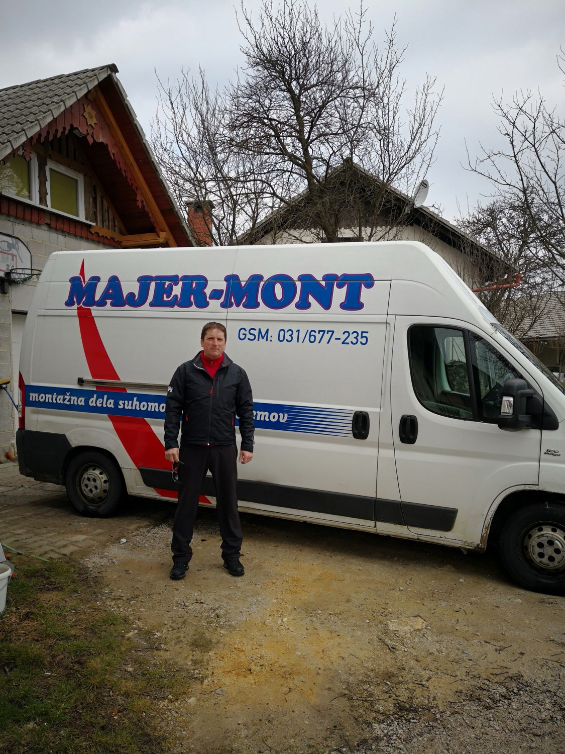 Vojko Žibert — suhomontažer, ustanovitelj Majer-Mont, pred službenim kombijem z logotipom podjetja.